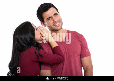 Studio shot of young woman smiling with woman whispering Banque D'Images