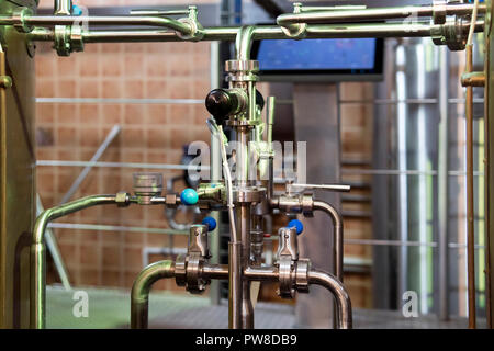 Close up d'équipements à l'intérieur moderne de brasserie. Processus de brewage Manufacturable. Tuyaux, tubes mélangeurs et jonctions dans une brasserie Banque D'Images