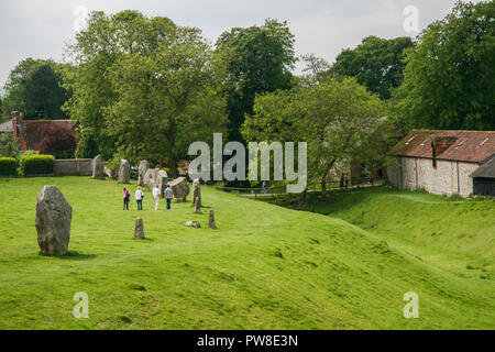 Les gens hommes et femmes marchant autour d'Avebury henge monument néolithique des cercles autour du village d'Avebury dans le Wiltshire, Angleterre, Royaume-Uni Banque D'Images