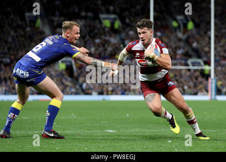 Wigan Warriors' Oliver Gildart (à droite) passe Warrington Wolves' Kevin Brown (à gauche) au cours de la Grande Finale de la Super League Betfred à Old Trafford, Manchester. Banque D'Images