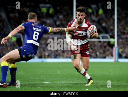 Wigan Warriors' Oliver Gildart (à droite) passe Warrington Wolves' Kevin Brown (à gauche) au cours de la Grande Finale de la Super League Betfred à Old Trafford, Manchester. Banque D'Images