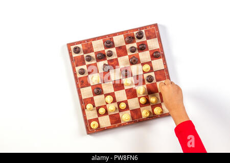 Kid mains sur un échiquier jouant aux échecs. Vue d'en haut Banque D'Images