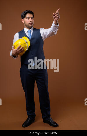 Beau jeune homme d'affaires iranien avec casque de protection contre brown ba Banque D'Images