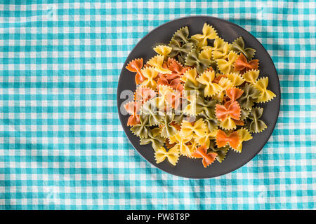 Pâtes Farfalle. Les pâtes italiennes colorés sur la plaque. Banque D'Images