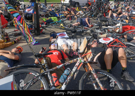 Londres, Royaume-Uni. 13 octobre 2018. Les gens prennent part à une dizaine de minutes de die-in par arrêter de tuer les cyclistes à l'extérieur du Parlement à la fin de la procession funéraire derrière un corbillard tiré par des chevaux à mettre en lumière l'échec des gouvernements de toutes les grandes parties à prendre des mesures exhaustives sur les pratiques sécuritaires de la randonnée à vélo. Arrêter de tuer les cyclistes appel à £3 milliards par an pour être investi dans un réseau national d'aires protégées à vélo et pour une action urgente pour réduire les rejets toxiques la pollution de véhicules diesel et essence qui tue des dizaines de milliers de personnes chaque année, et désactive des centaines de milliers. Après le dé-dans la seve Banque D'Images