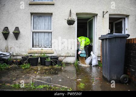 Samedi 13 octobre 2018. Tonna, South Wales, UK. Les inondations effectuée les villages d'Aberdulais et Tonna dans la Neath Valley après la tempête Callum a de fortes pluies et au vent pour la zone d'Neath River pour atteindre le point de rupture. Un homme essaye de vider sa maison de l'eau à côté du canal, Tonna, Neath. Robert Melen/Alamy Live News. Banque D'Images