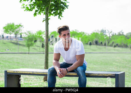 Homme musclé attrayant dans city park looking away Banque D'Images