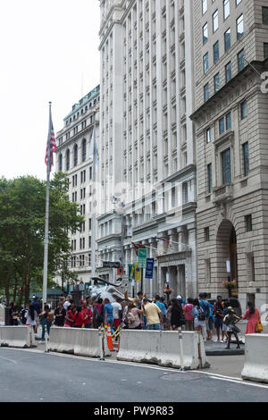 NEW YORK, NEW YORK - 19 août 2018 : les touristes essaient de se rapprocher de la sculpture Bull Charge dans le quartier financier de Manhattan Banque D'Images