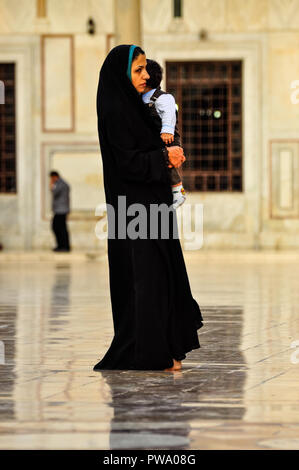 Femme portant un tchador tenant son fils dans la mosquée des Omeyyades, Damas, Syrie Banque D'Images