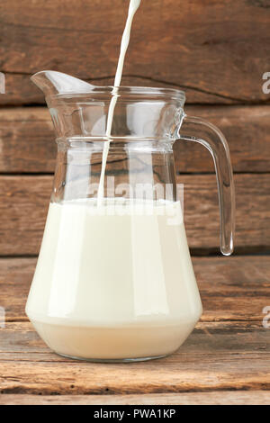 Verser le lait dans un pichet. Remplir un pichet de verre de lait frais. Lait Eco concept. Banque D'Images