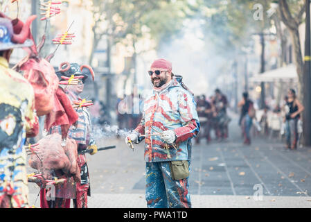 Les hommes de démarrer le feu pour le Correfoc parade lors de la Festa Major à Vilanova i la Geltru'. Barcelone, Catalogne. Août 2018 Banque D'Images