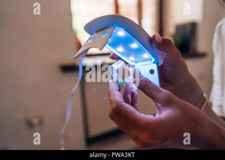 Le master sur la colle avec une lampe à ultraviolet Banque D'Images