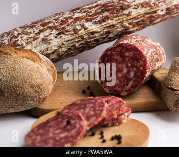 Des saucisses avec du pain et le poivre morceaux sur fond blanc Banque D'Images