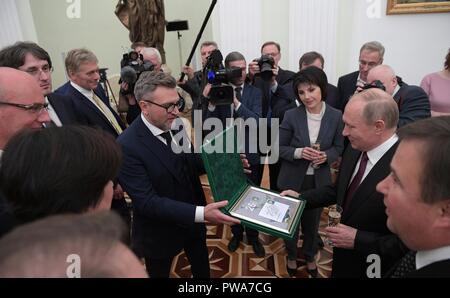 Le président russe Vladimir Poutine est présenté avec un timbre commerative par le personnel de la télévision russe NTV au cours d'une célébration marquant le 25e anniversaire des radiodiffuseurs au Kremlin, le 12 octobre 2018 à Moscou, Russie. Banque D'Images