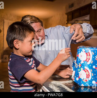 Jeune enfant cadeau de Noël d'enrubannage. Avec l'aide de papi Série de 7 images. M. © Myrleen Pearson ...Ferguson Cate Banque D'Images