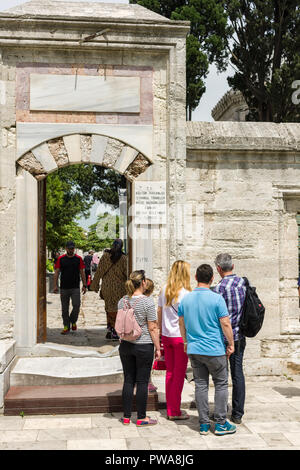 Les touristes se tiennent à l'extérieur une arche de pierre porte qui mène à la Mosquée de Suleymaniye sur une journée de printemps ensoleillée, Istanbul, Turquie Banque D'Images