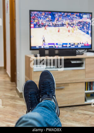 Vue à la première personne d'un homme qui regarde un match de basket-ball à la télévision Banque D'Images