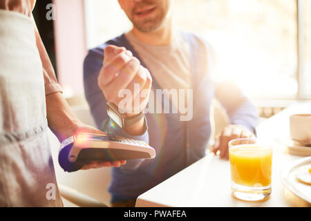 Main de businessman with smartwatch au paiement détenus par la machine serveuse Banque D'Images