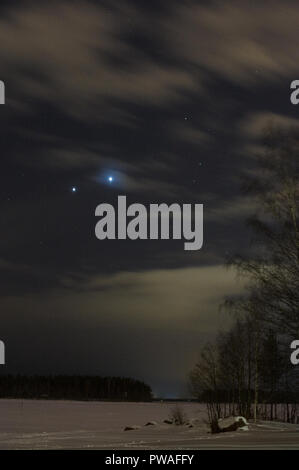 Concert de planètes Jupiter et Vénus le ciel nocturne au-dessus de paysage d'hiver enneigé. Banque D'Images