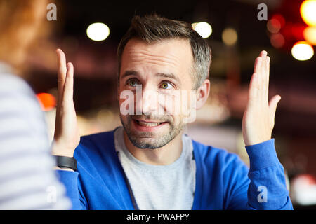 Businessman with a soulevé les mains essayant d'expliquer quelque chose à un collègue à la réunion Banque D'Images