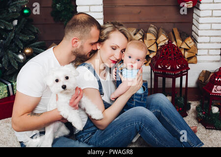 Positivity family posing ensemble près de cheminée et présente pour Noël Banque D'Images