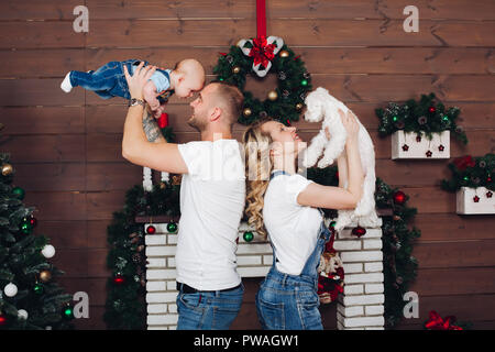 Positivity family posing ensemble près de cheminée et présente pour Noël Banque D'Images