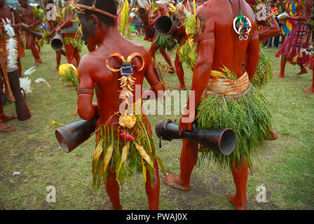 Habillés de couleurs vives et le visage peint les hommes avec la batterie dans le cadre d'une danse Sing Sing à Madang, Papouasie Nouvelle Guinée. Banque D'Images