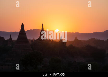 Silhouettes de pagodes birmanes tandis que soleil se couche dans les montagnes, Bagan, Myanmar Banque D'Images