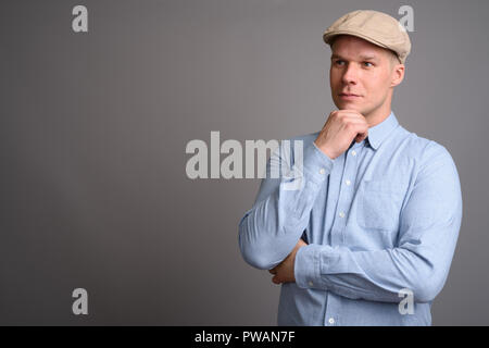 Man wearing hat finlandais contre l'arrière-plan gris Banque D'Images