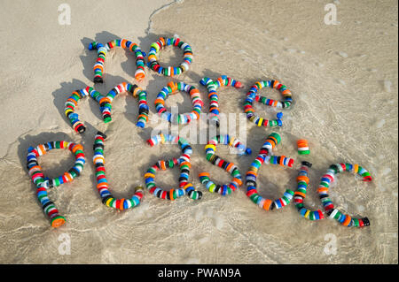 Plus aucun message en plastique fabriqués à partir de la bouteille utilisée colorés déchets sur le sable doux rivage d'une plage tropicale Banque D'Images