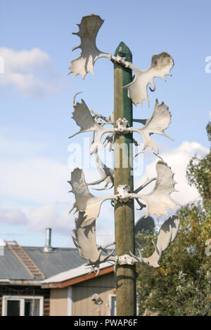 Old Crow, Canada. Native American Indian totem hors de l'orignal et le caribou des bois. Chambre avec une échelle sur le toit la bakground. Banque D'Images