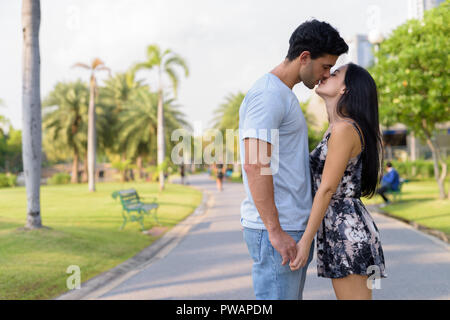 Young Hispanic couple relaxing in the park ensemble Banque D'Images