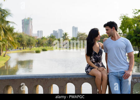 Young Hispanic couple relaxing in the park ensemble Banque D'Images