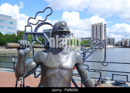 Depuis la fosse au Port, statue en bronze d'un mineur de charbon par John Clinch, la baie de Cardiff, Cardiff, Pays de Galles, Royaume-Uni Banque D'Images