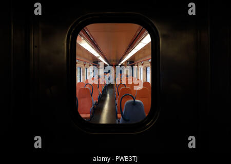 Un homme assis seul sur un train vide Autrement Banque D'Images