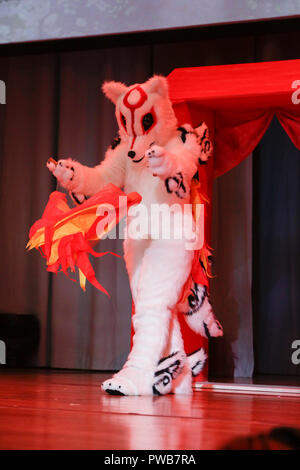 Francfort, Allemagne. 14 octobre 2018. Un participant joue sur la scène comme Amaterasu du jeu vidéo Okami. Le 12. Championnat Cosplay allemand a eu lieu dans le cadre de la 70e Foire du livre de Francfort 2018, avec 24 participants en compétition sur scène en costumes de personnages différents à partir de la tv, jeux vidéo séries télé et films.. Banque D'Images