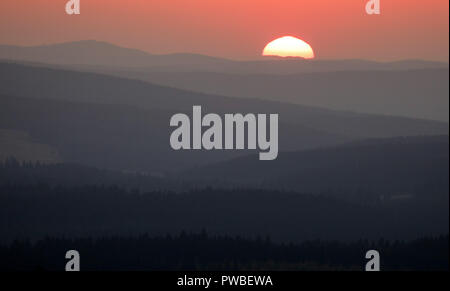 Oberwiesenthal, Saxe. 14Th Oct, 2018. Le soleil se couche derrière les crêtes de l'Westerzgebirge. Crédit : Jan Woitas/dpa-Zentralbild/dpa/Alamy Live News Banque D'Images