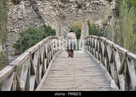 Vieille Femme sur le pont suspendu en bois dans le village de Balti, Turtuk La Vallée de Nubra, Ladakh, Inde Banque D'Images