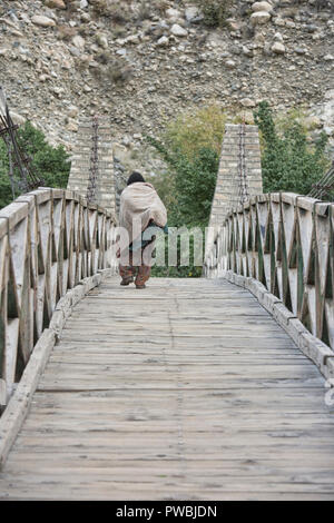 Vieille Femme sur le pont suspendu en bois dans le village de Balti, Turtuk La Vallée de Nubra, Ladakh, Inde Banque D'Images