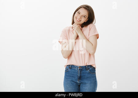 Vous êtes si mignon je suis touché. Portrait de femme charmante dans le quartier branché d'HEUREUX T-shirt, tête inclinable et tout sourire, serrant les mains ensemble tout en étant déplacé avec agréable surprise Banque D'Images