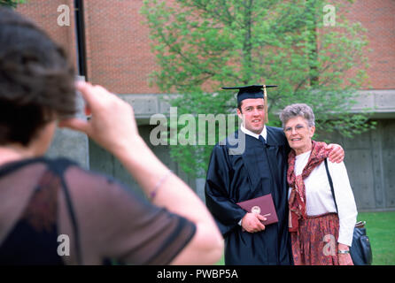 Diplômé de l'université pose avec grand-mère tandis que la maman prend photo, USA Banque D'Images