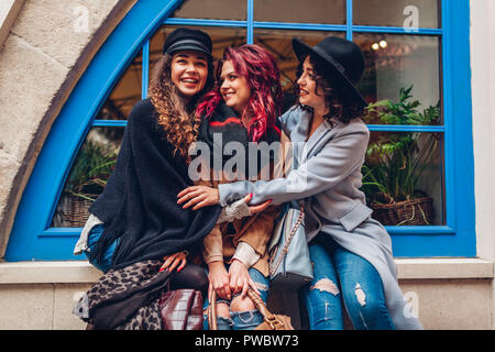 Young women hugging and laughing on city street. Meilleurs amis, pour avoir du bon temps ensemble. Happy girls having fun Banque D'Images