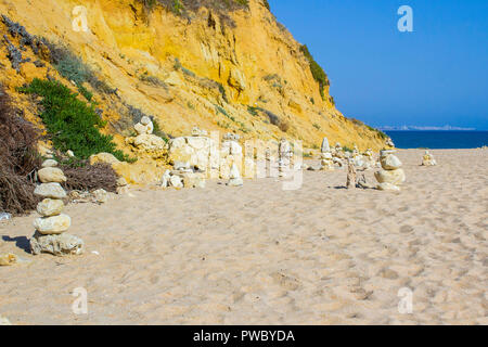 Sculptures de roche sur une partie déserte de la plage de Praia da Oura dans Alburian sur l'Algarve, au Portugal à Vilamoura dans l'arrière-plan lointain Banque D'Images