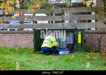 Bt openreach ingénieur téléphone agenouillé devant une armoire de câblage, Kent, UK Banque D'Images