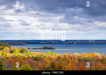 Briser les nuages soleil apparaît pour définir l'automne feuillage en feu près du lac Couchiching Orillia Ontario Canada. Banque D'Images