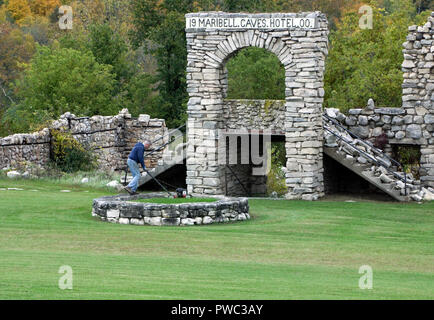 Le fauchage de l'herbe en gardien de la fondation fontaine circulaire en face des ruines de l'hôtel Maribel historique Banque D'Images