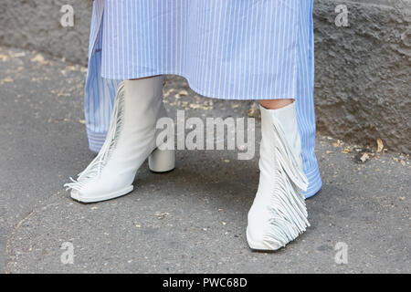 MILAN, ITALIE - 20 septembre 2018 : Femme avec des chaussures blanches avec des franges et robe rayée bleu et blanc avant Fendi fashion show, Milan Fashion Week Banque D'Images