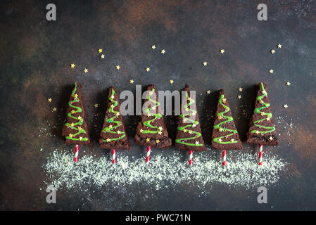 Brownies au chocolat en forme d'arbres de Noël avec glaçage vert et festive sprinkles, vue de dessus, copiez l'espace. Vacances d'hiver ou de noël sucré pastry Banque D'Images