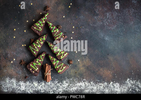 Brownies au chocolat en forme d'arbre de Noël avec glaçage vert et festive sprinkles, vue de dessus, copiez l'espace. Vacances d'hiver ou de noël sucré pastry Banque D'Images