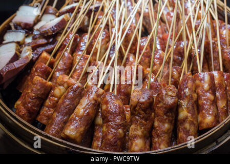 Les brochettes de saucisses avec de la viande crue dans une plaque dans un marché chinois, Chengdu, Chine Banque D'Images